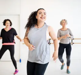 Adults and instructor flexing at group dance class at YMCA Louisville