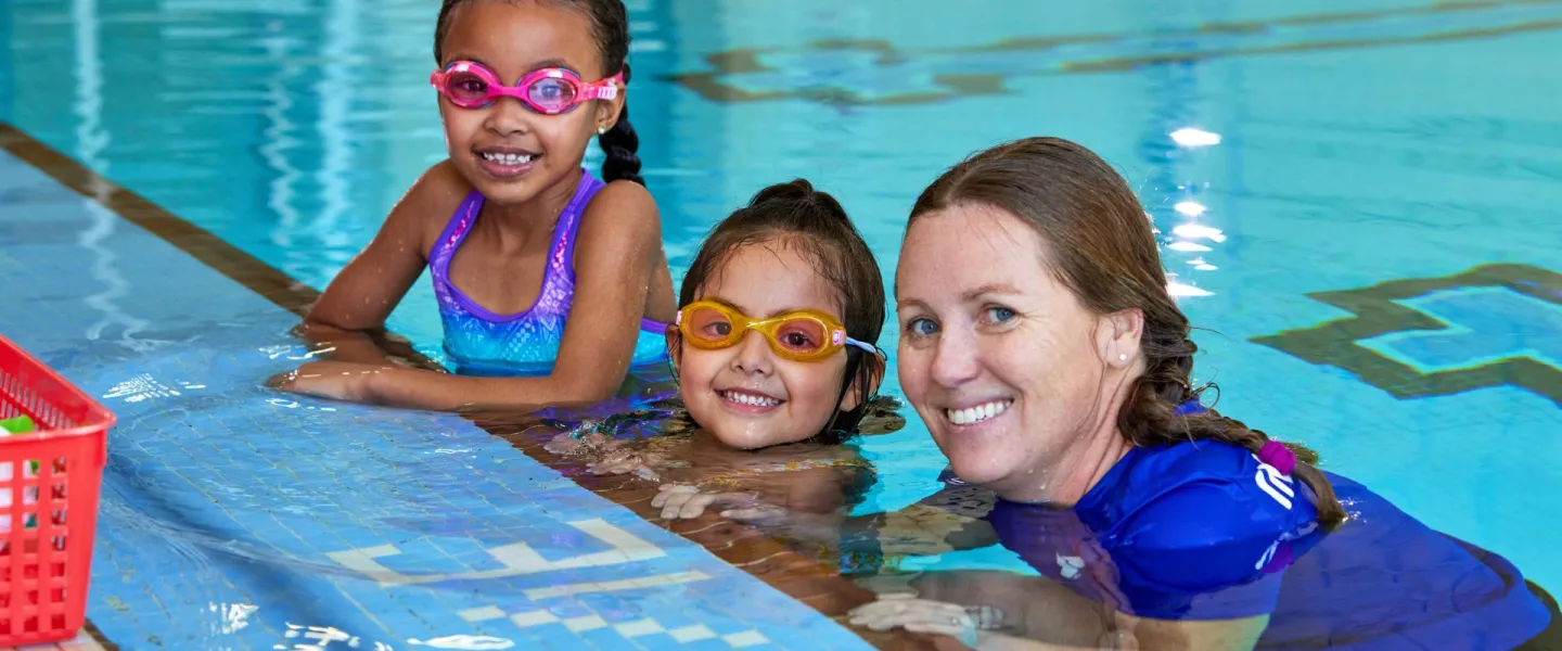 Kids with a YMCA swim instructor in the pool