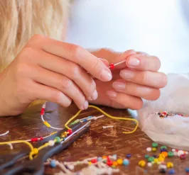 Person at table crafting a necklace