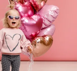 Girl wearing sunglasses holding balloons