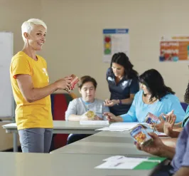 YMCA employee teaching classroom of children and adults